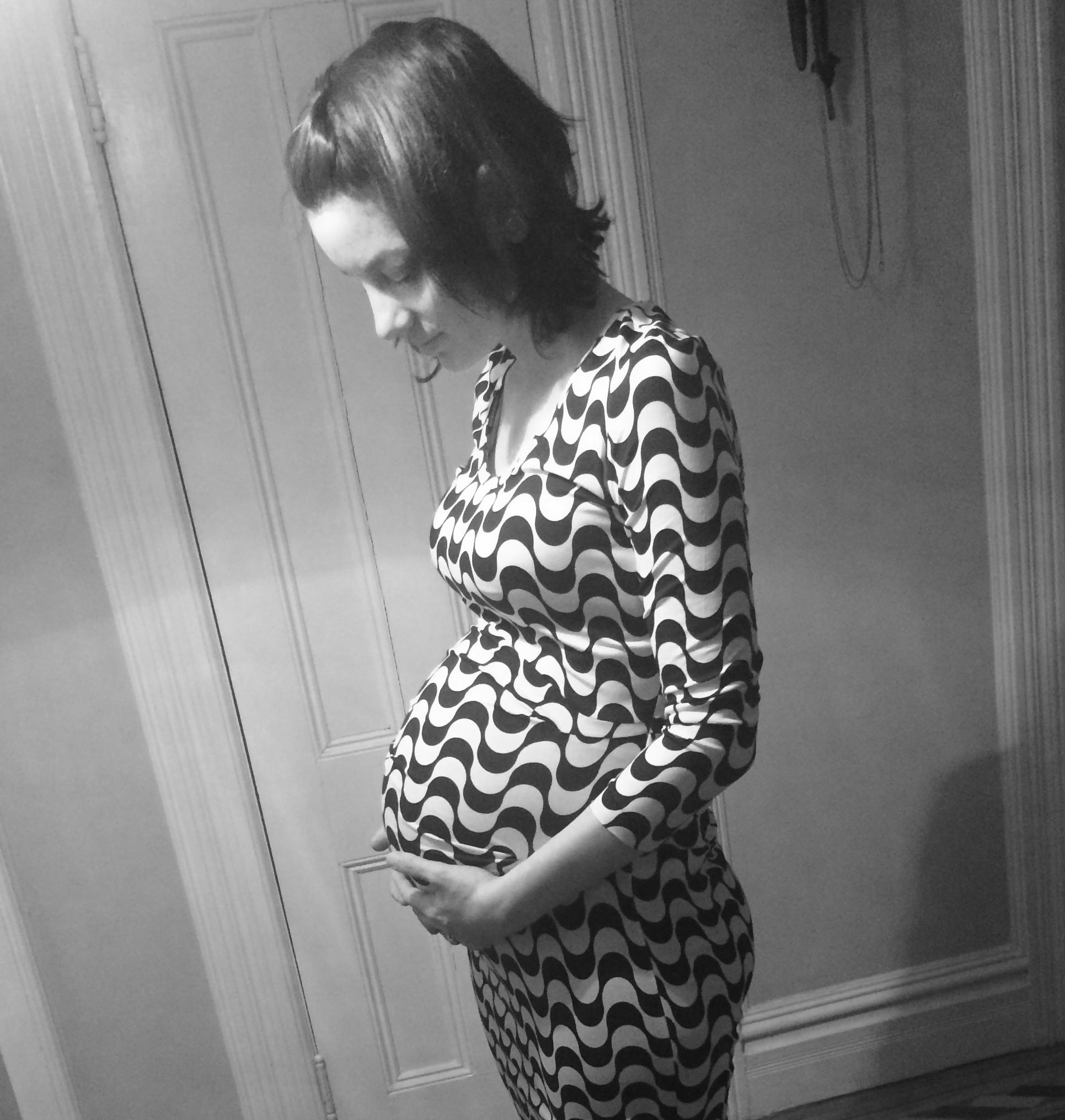 Christina Corrozza, client of Tribe of Mine, holding her pregnant belly.