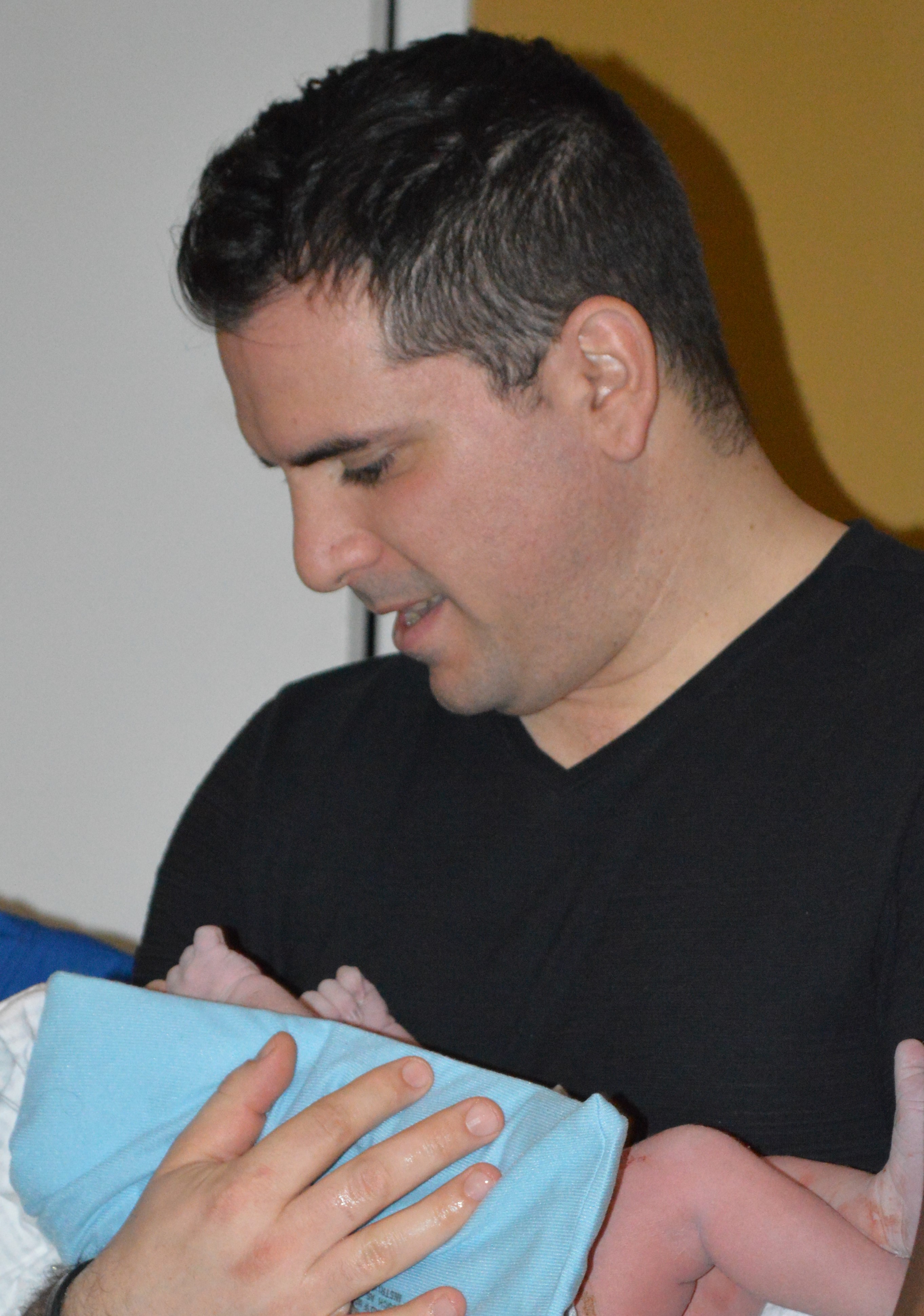 Mario Nicolaou, client of Tribe of Mine, feeding his newborn baby girl.