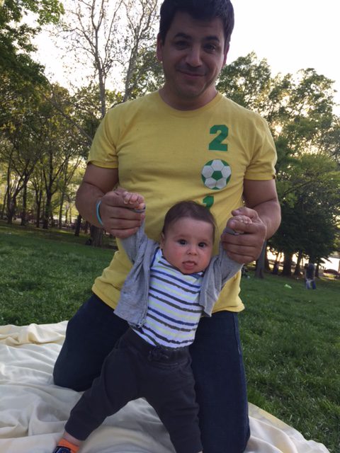 Joe Marino and his toddler Leo on a blanket at the park - clients of Tribe of Mine
