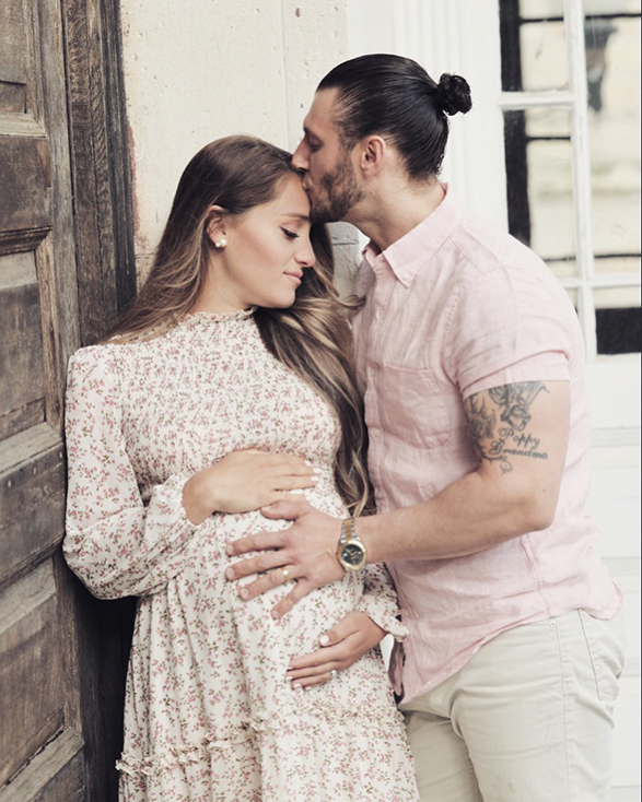 Pregnant Couple embracing outside